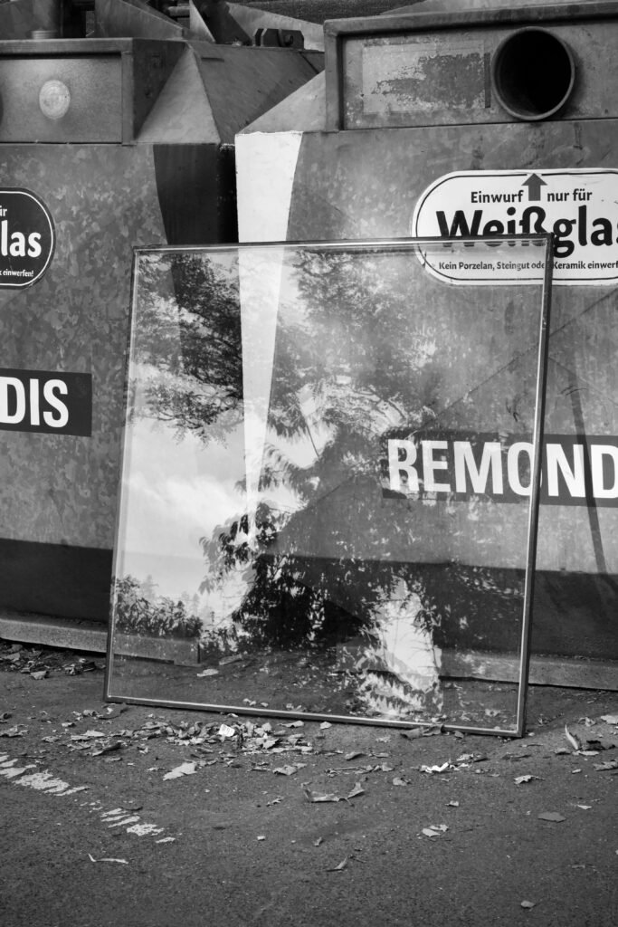 Black and white photo of a glass reflection in an urban alley, showcasing reflections.
